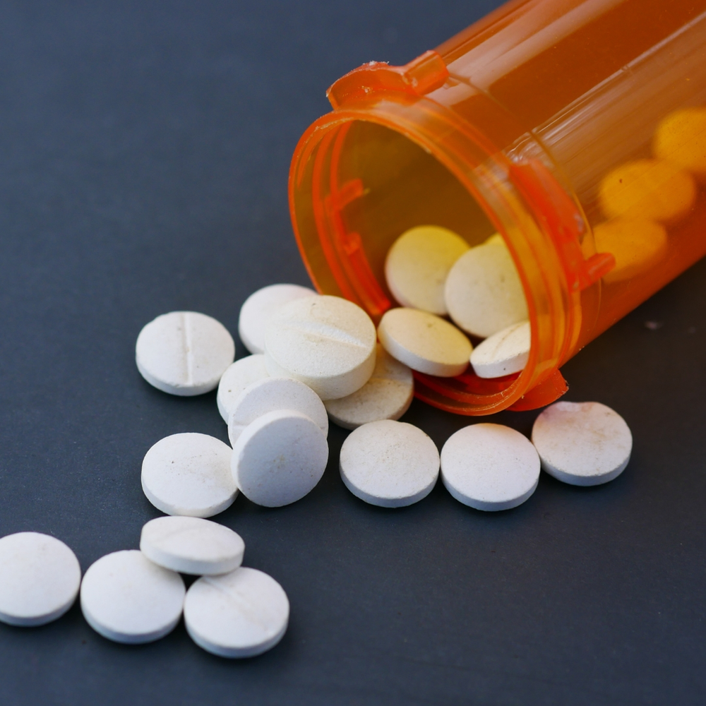 pote de capsulas laranja aberto demonstrando capsulas brancas