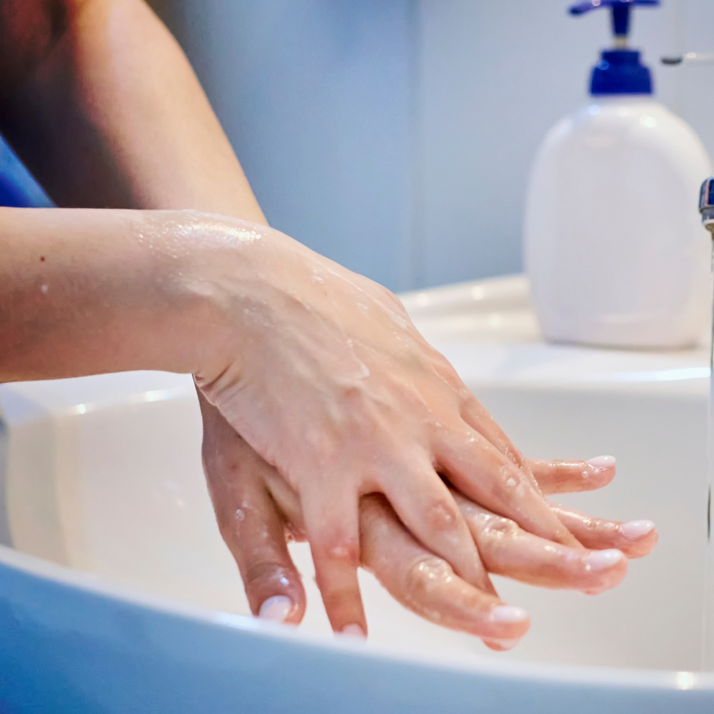 umamulherlavandoasmãonapia uma mulher lavando as mãos na pia